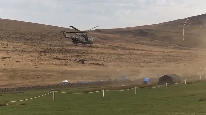 A video capture from an Internet ISIS video showing the porta potties being scattered by a Merlin helicopter.